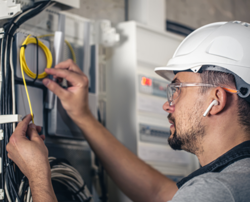 Proiecte de îmbunătățire a locuinței unde trebuie să angajezi un electrician 3 man electrical technician working switchboard with fuses 1