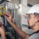 man electrical technician working switchboard with fuses 1